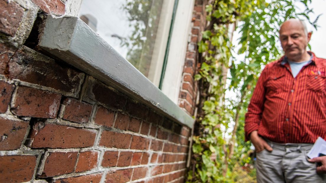Een inwoner van Woltersum bekijkt de aardbevingsschade aan zijn woning