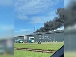 Rookwolken stijgen op uit de loods aan de Montrealweg