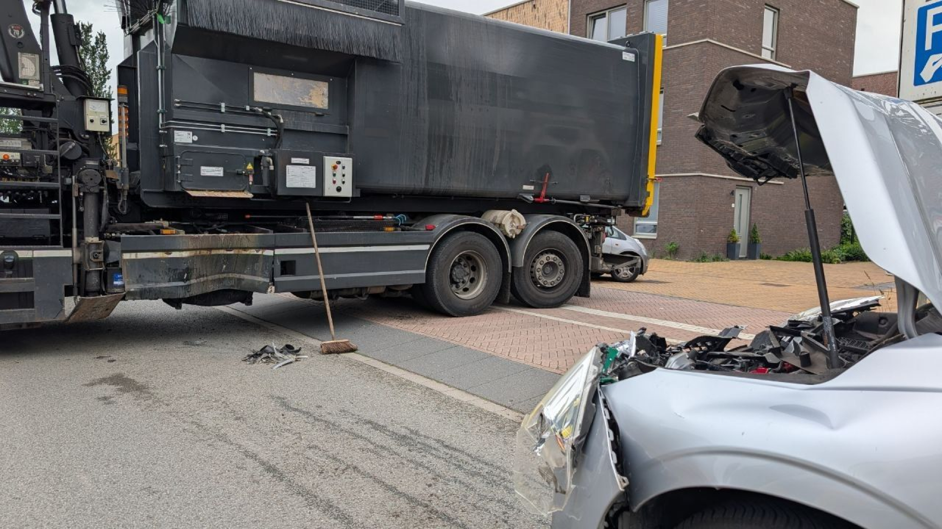 Brommerrijder in de sloot • botsing met afvalwagen