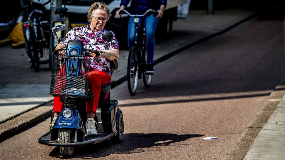Een vrouw in een scootmobiel op een fietspad