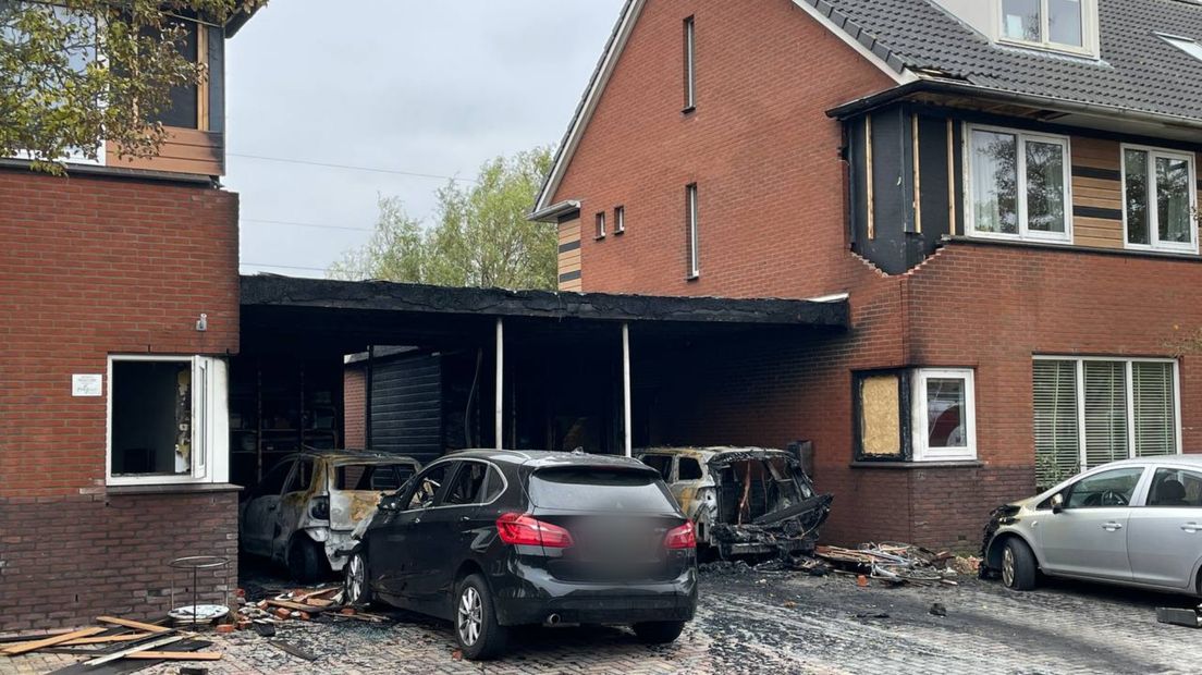 De beschadigde woningen met de uitgebrande auto's op de oprit