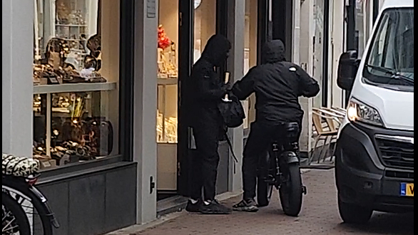 Met een hamer en tas mét buit verlaten de overvallers de juwelier.