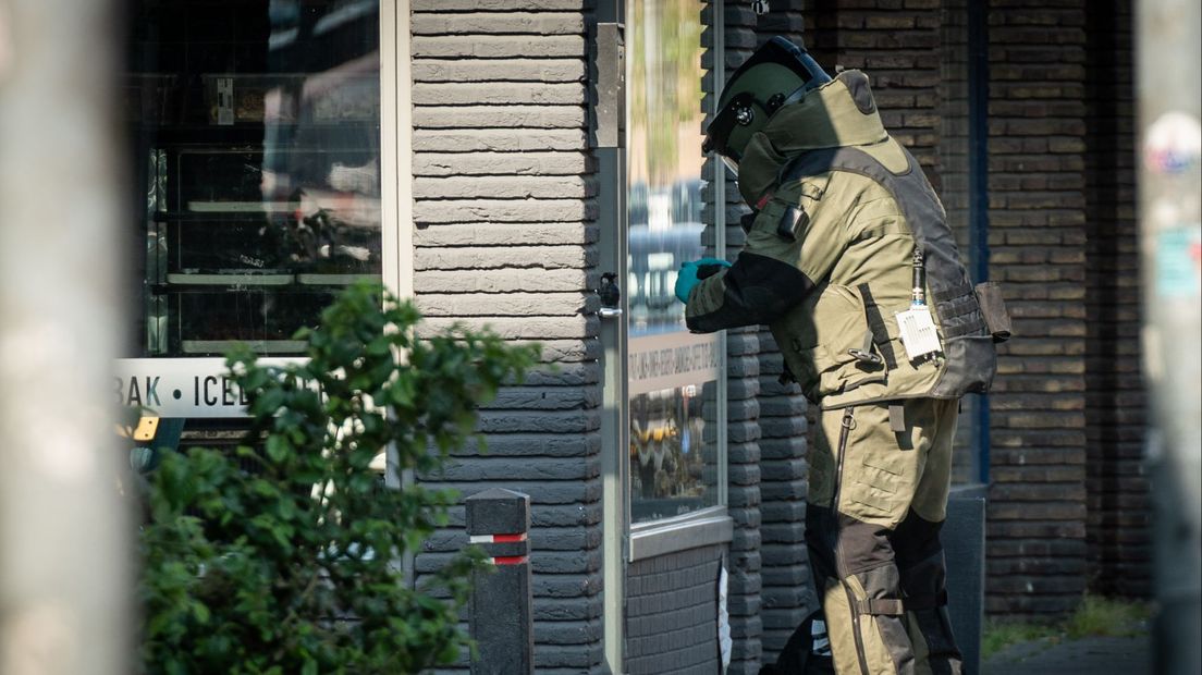 Iemand van de EOD onderzoekt de gevonden granaat