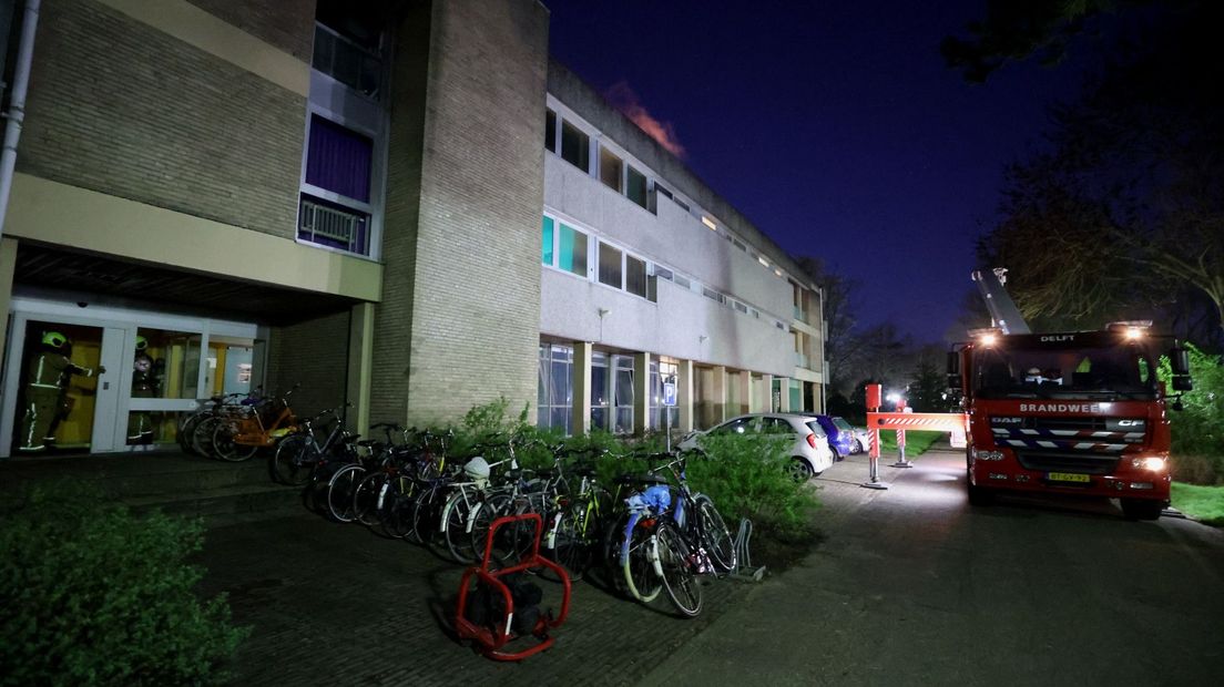 De vlammen slaan uit het dak van de studentenflat