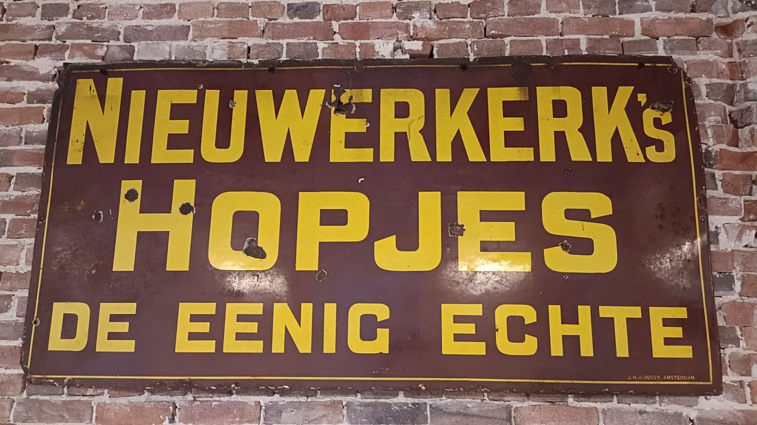 Een emaille reclamebord van de originele producent, zoals te zien in het museum