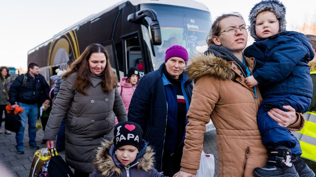 Een moeder met twee kinderen stapt uit de bus