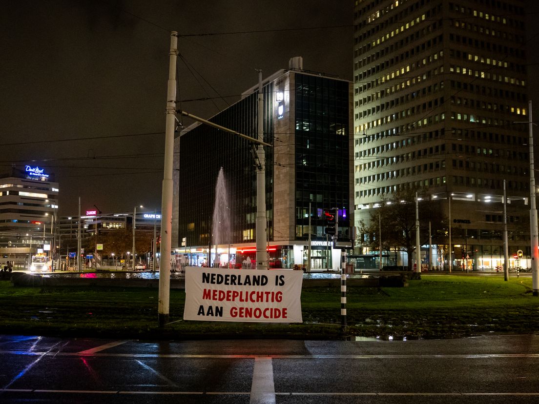 Het spandoek dat Justice Now ophing bij de Hofpleinfontein in Rotterdam