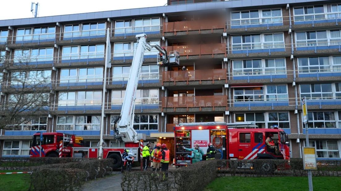 De brandweer haalt bewoners met een hoogwerker van hun balkons