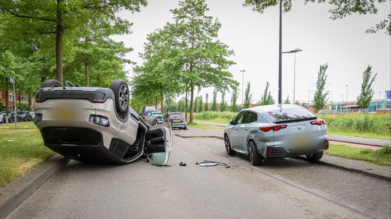 Auto botst tegen geparkeerde auto en slaat over de kop