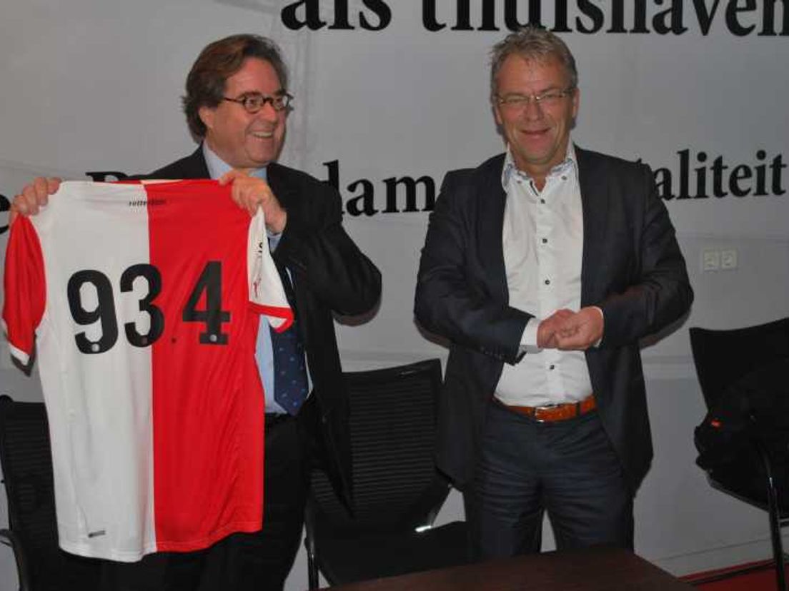 RTV Rijnmond-directeur Wehrmeijer (links) neemt het Feyenoordshirt in ontvangst van Feyenoord-directeur Gudde