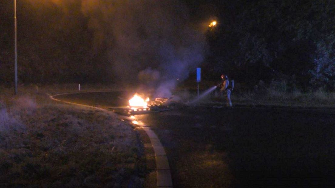 De brandweer blust de pallets op de oprit van de A7