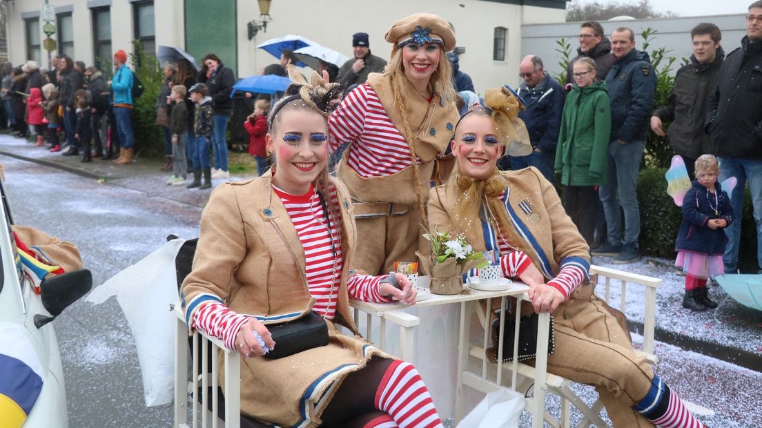 Een bescheiden praalwagen en drie deelnemers die zich kostelijk vermaken