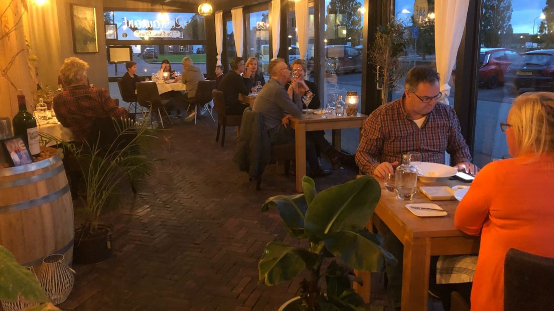 Mensen eten in een restaurant in Zoutkamp, kort voordat de horeca dicht ging