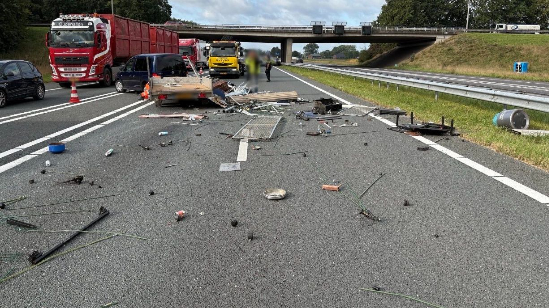 Aanhanger met schroot kantelt, opruimwerkzaamheden op A18