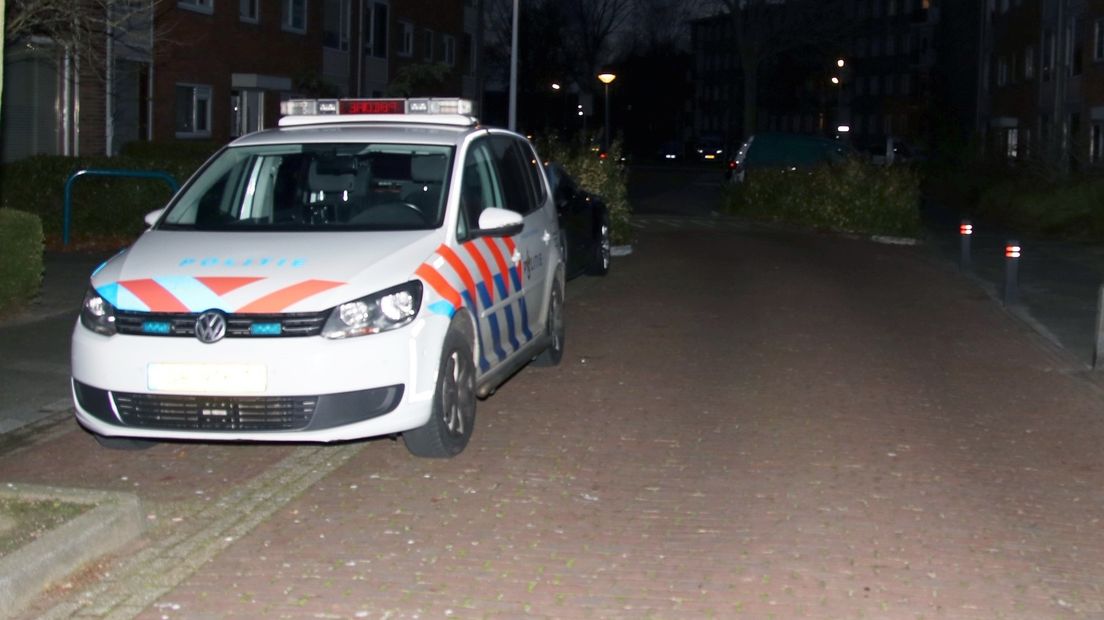 Politie-auto in de straat waar een overleden vouw is gevonden in haar woning
