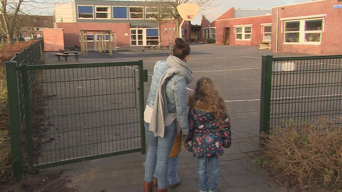 Ouders en kinderen kijken naar de gevolgen van de brand