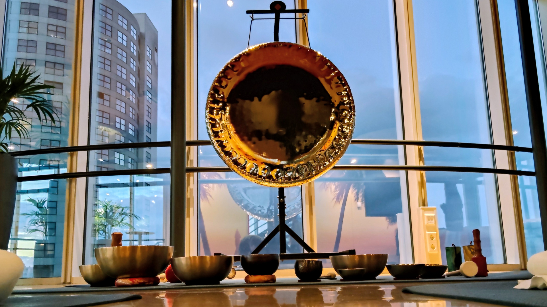 Klankschalen op de grond en een enorme gong als onderdelen van een sound bath