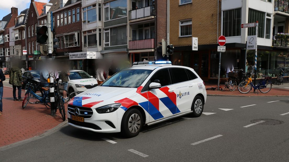 Omstanders ontfermen zich over de aangereden fietser op de Ebbingestraat