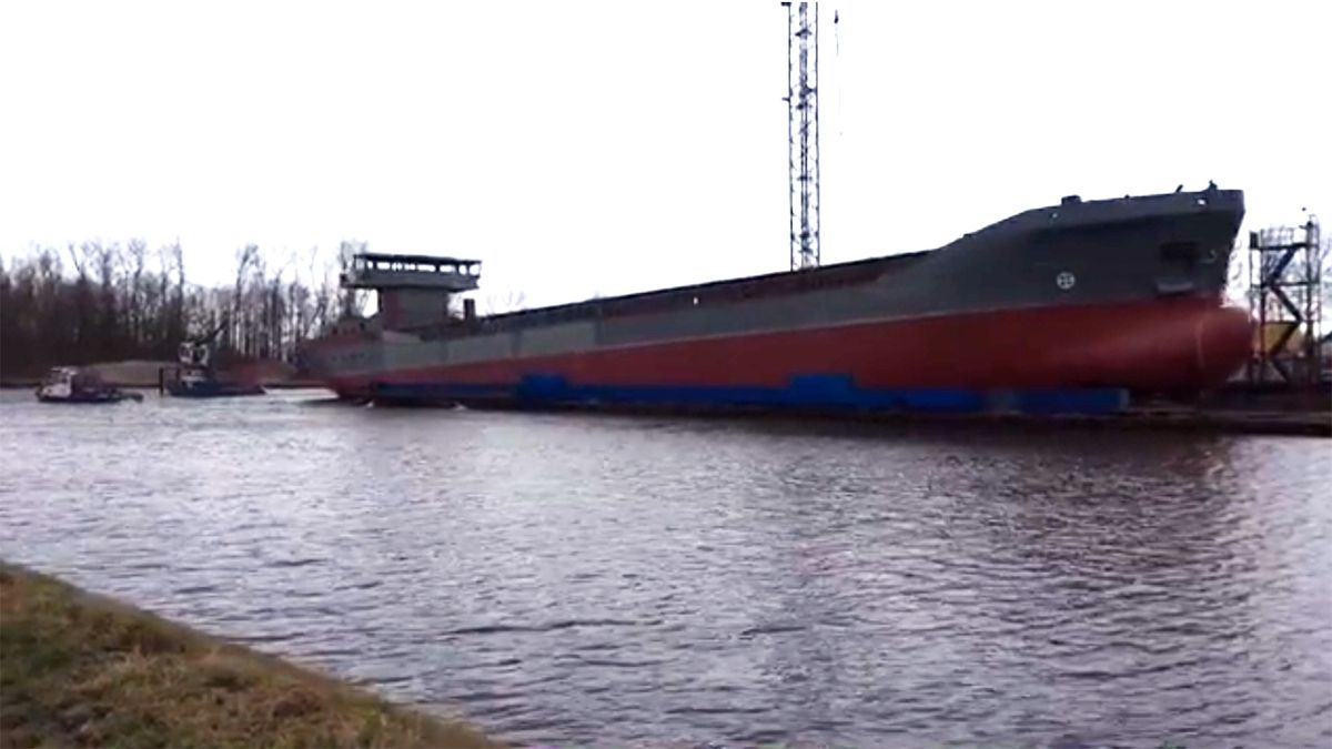 Transportschip glijdt achterwaarts het water in bij Waterhuizen