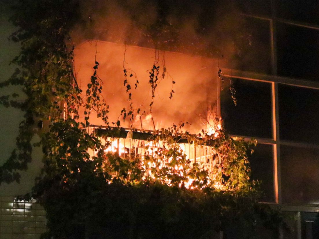 De vlammen slaan uit het appartement na de explosie