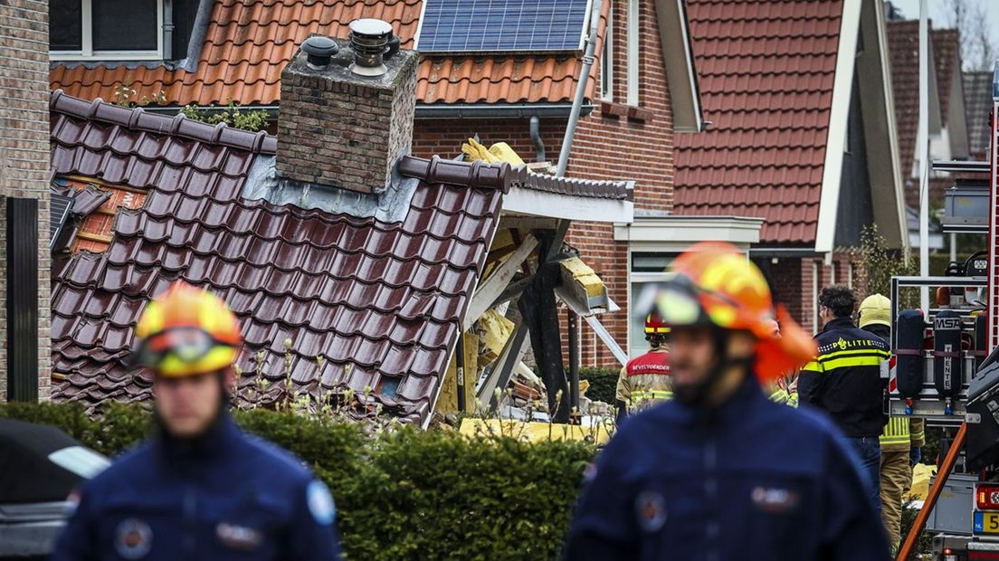 Twee reddingswerkers voor het ingestorte huis in Oldenzaal