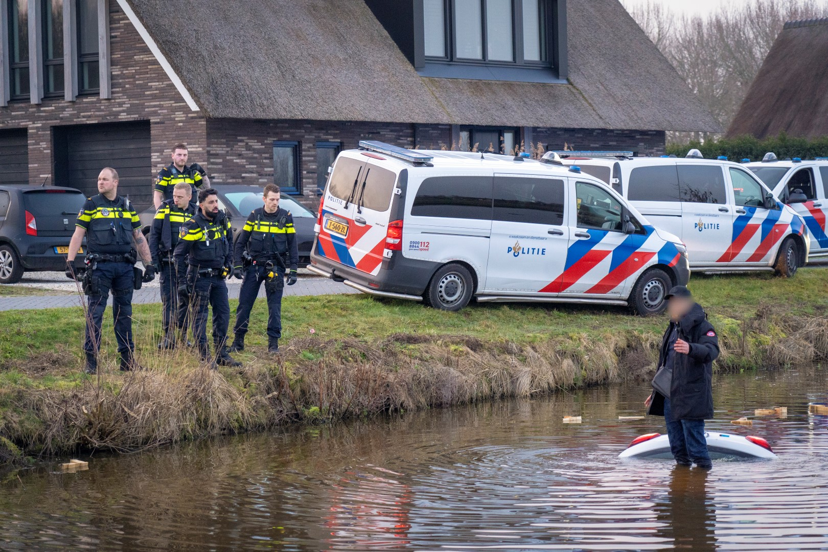 De man stond op het dak van zijn auto en weigerde in eerste instantie naar de kant te zwemmen.