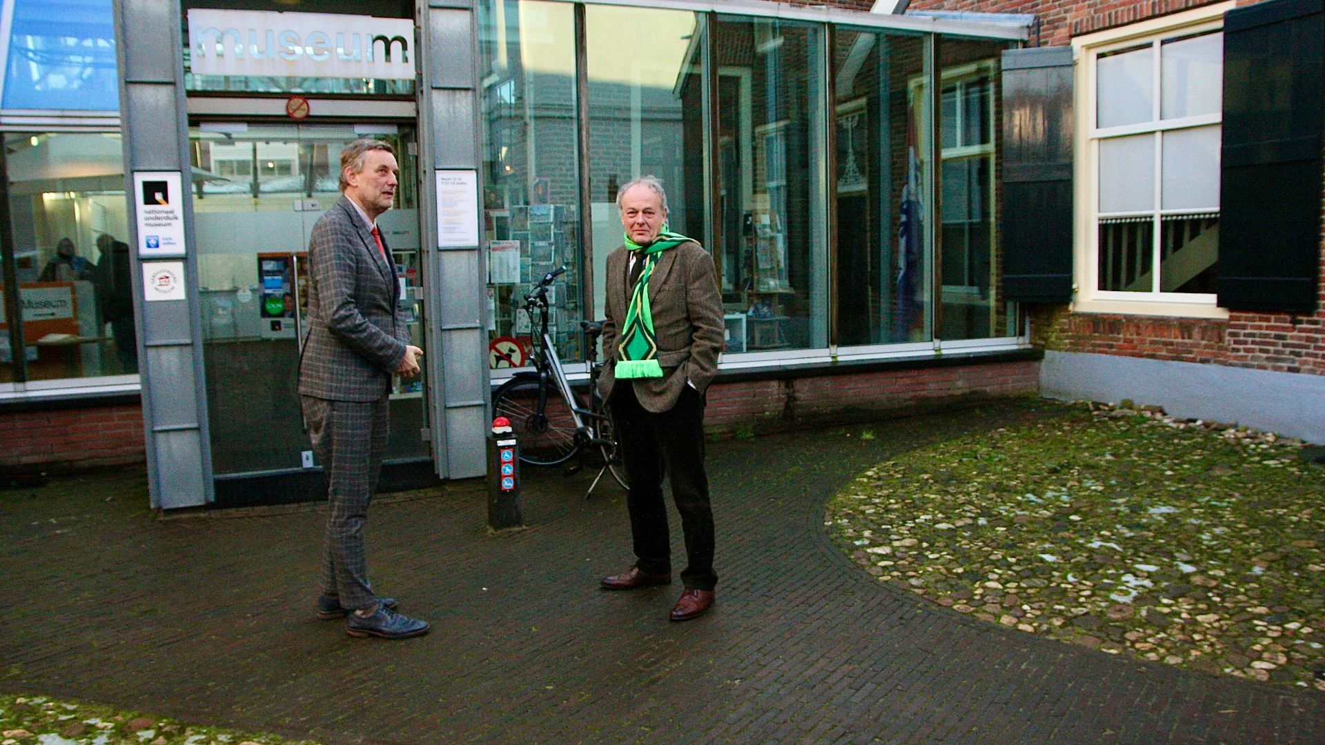 De Aaltense burgemeester Anton Stapelkamp (l) met de commissaris van de Koning Henri Lenferink (r) bij de entree van het Nationaal Onderduikmuseum.