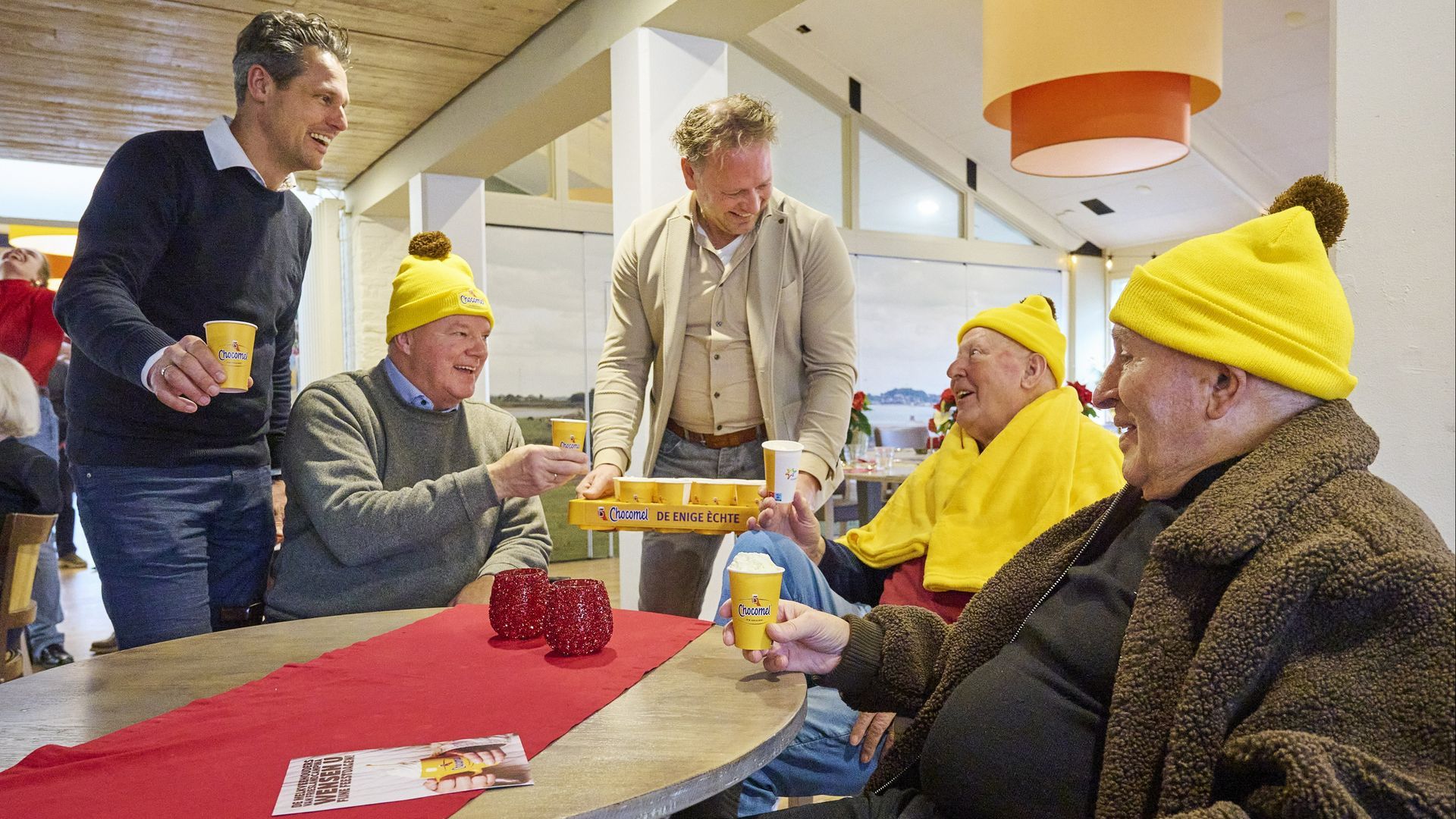 FrieslandCampina-melkveehouders delen warme Chocomel uit aan ouderen.
