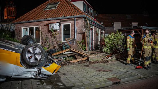 Auto buitelt via muur op stoep, puin vliegt door glazen deur