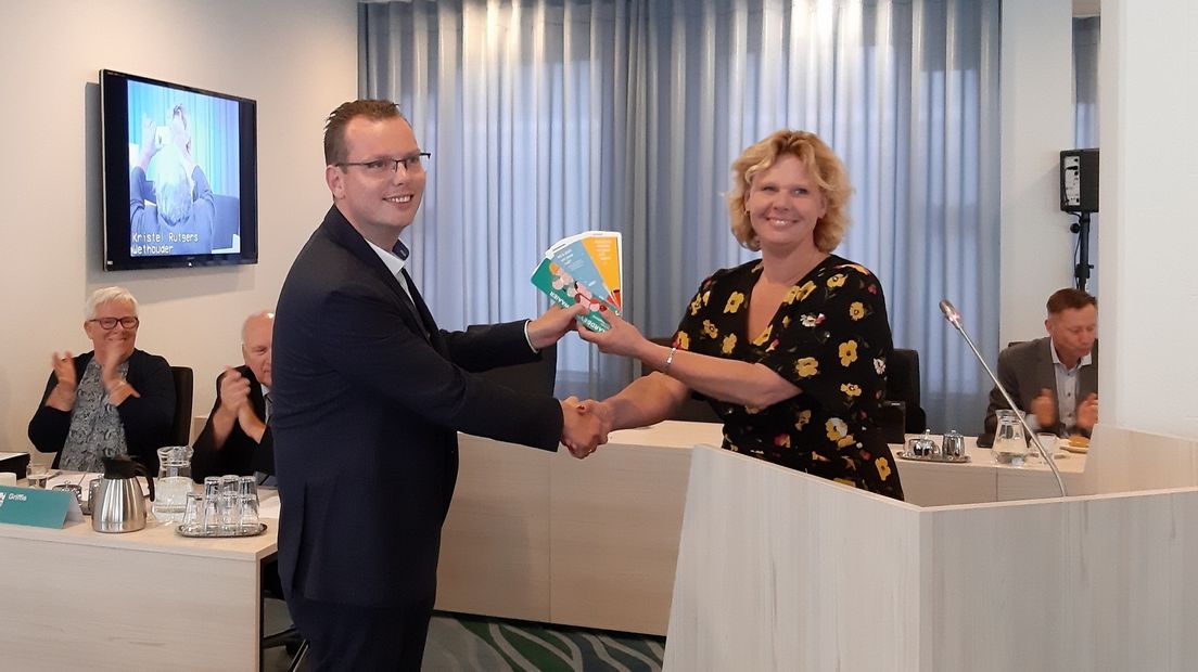 Raadslid Bernd de Jong krijgt van wethouder Kristel Rutgers de eerste aardbevingswaaier.