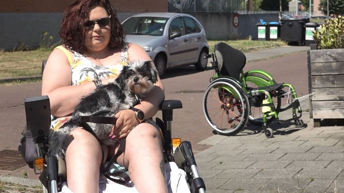 Dorothy Geurts met haar hondje in haar elektrische rolstoel.