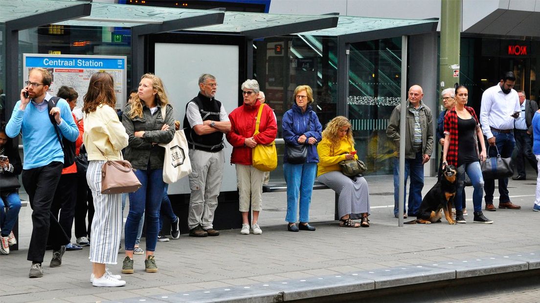 Reizigers wachten op de tram bij Den Haag Centraal