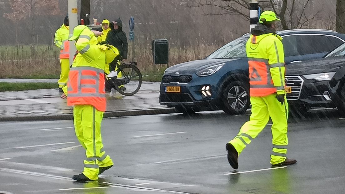 Oefenende verkeersregelaars en wachtende verkeersdeelnemers in Den Haag