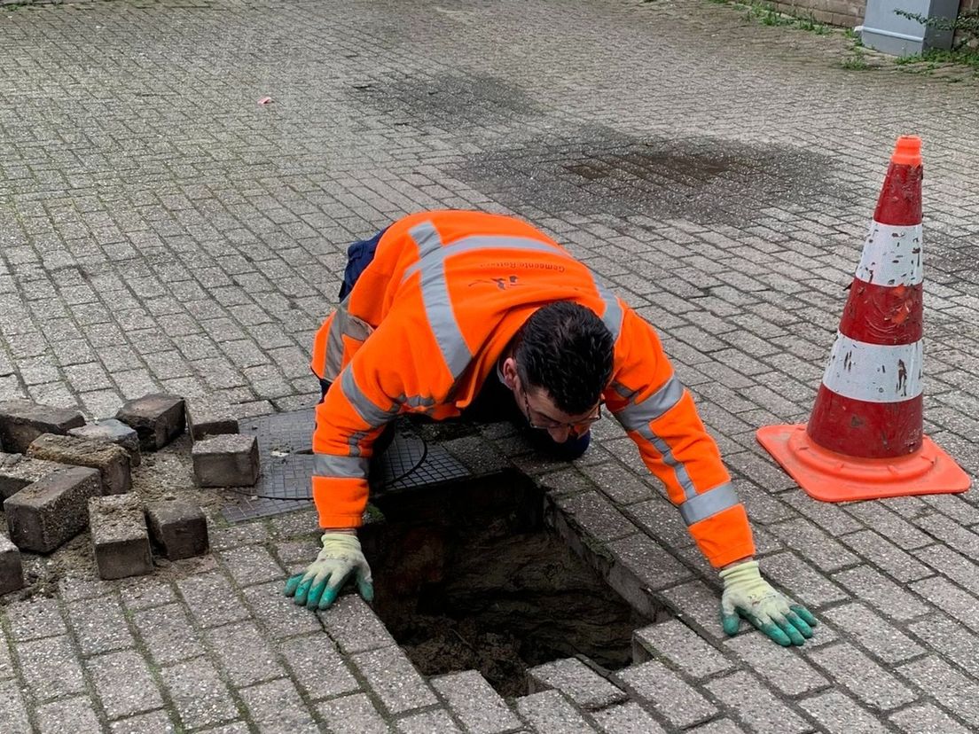 Een medewerker van de gemeente controleert een sinkhole