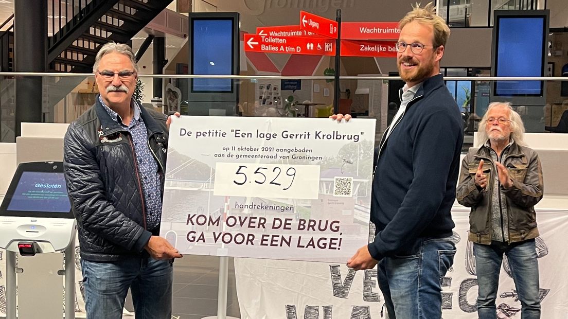 Chris van Malkenhorst (links) overhandigt een pamflet dat staat voor het aantal handtekeningen aan Rik van Niejenhuis