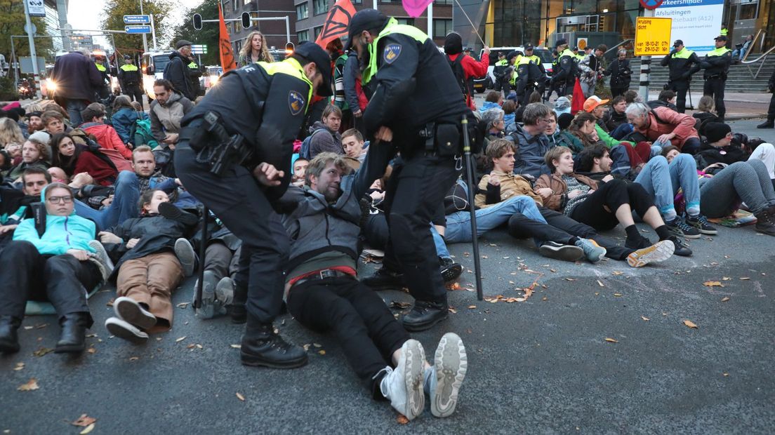 De politie haalt de demonstranten van het kruispunt