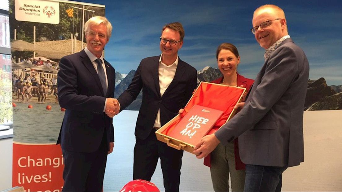 Wethouders Claudio Bruggink (Hengelo) en Rob Christenhusz (Oldenzaal) bieden het Twentse bidbook aan