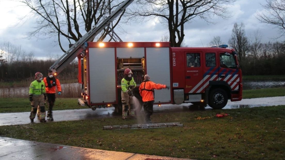 Brandweerlieden spuiten hun materialen schoon na de bevrijdingsactie