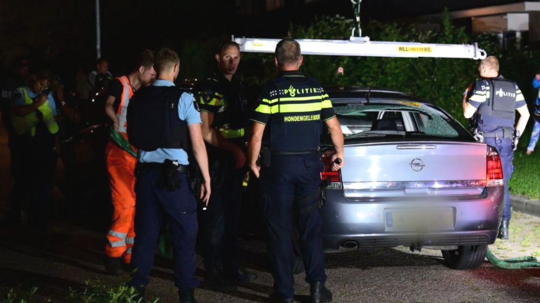Agenten onderzoeken de beschoten auto aan de Kleine Belt in Delfzijl