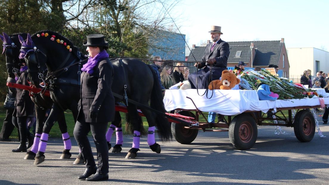 Achter prachtig versierde paarden lag Isabelle in een kist op de wagen