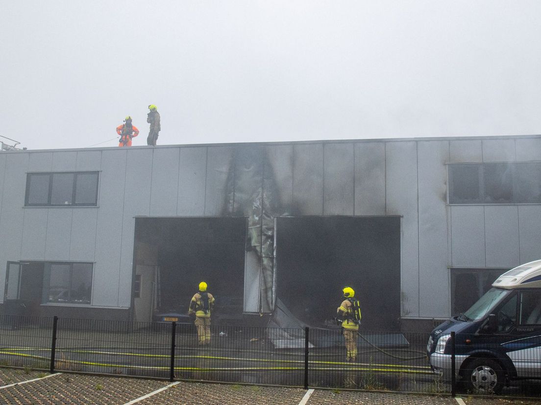 De brandweer doet onderzoek naar de brand op het dak van de garage in Strijen
