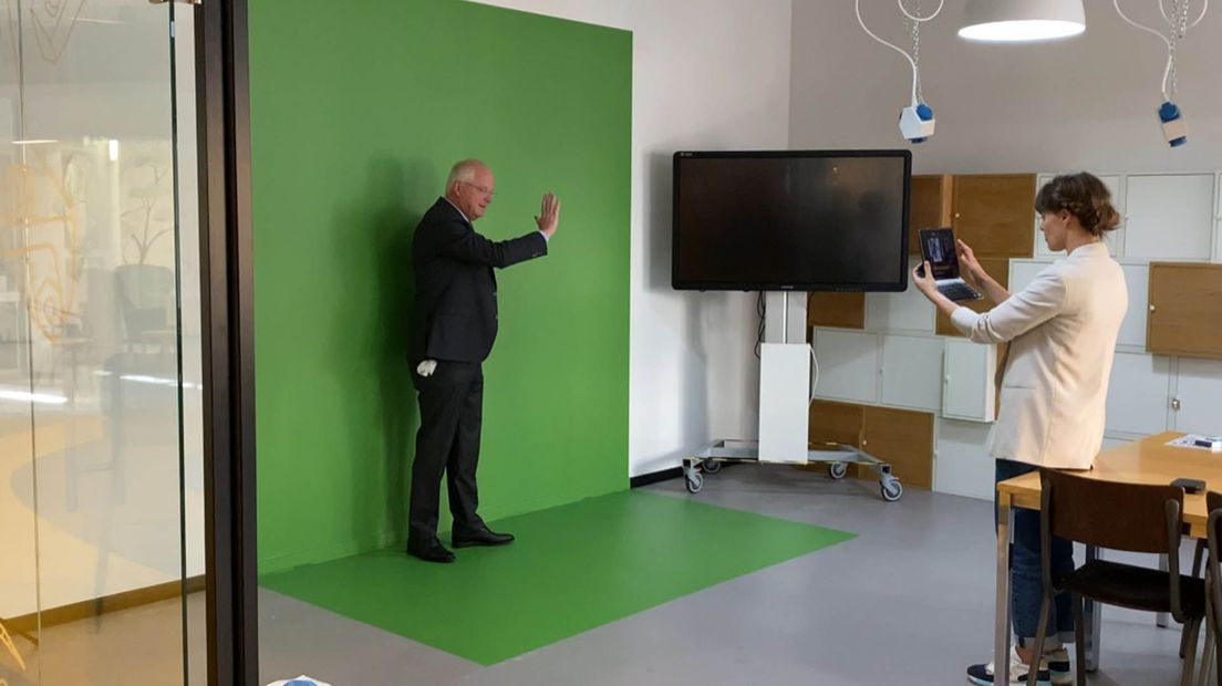 Wethouder Marcel Fluitman geeft een virtuele robot een high five.