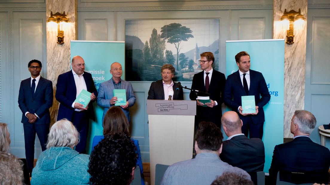 De overhandiging van het rapport.