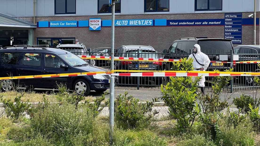 Medewerkers die het asbest opruimen, dragen beschermende, witte kleding