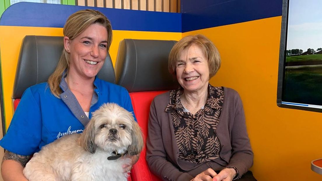 Louise Annema (l) maakt een tochtje met bewoonster Trudy en hond Turbo