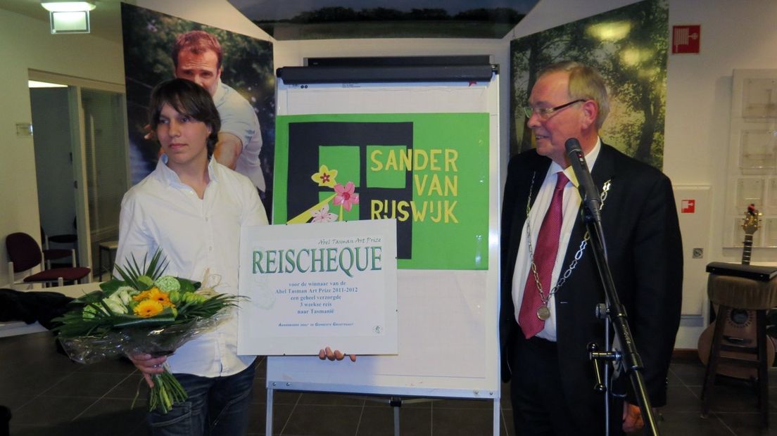 Sander van Rijswijk (l) en burgemeester Kor Dijkstra met tussen hen in het winnende kunstwerk.