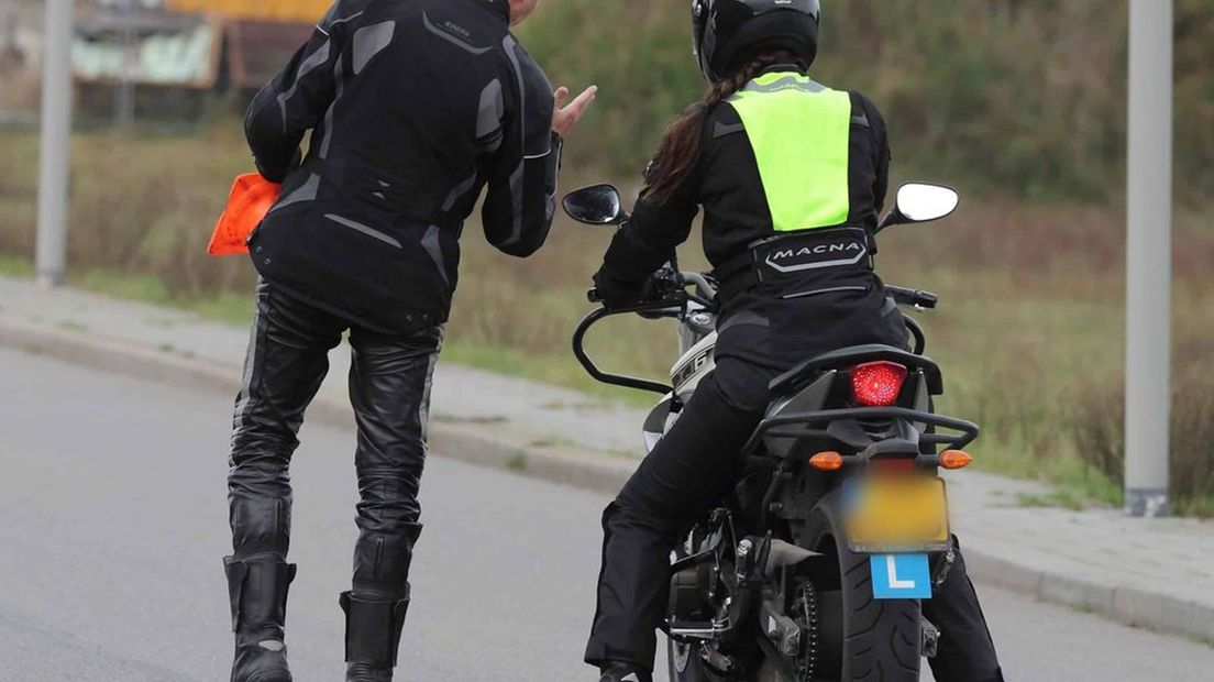 Een leerling krijgt motorrijles van een instructeur.
