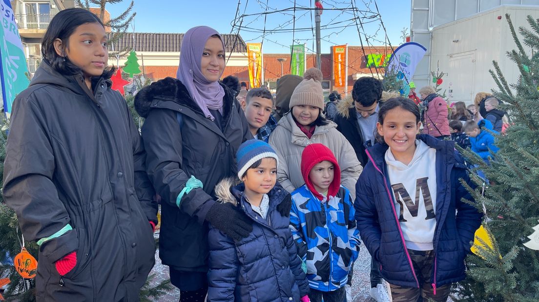 Kinderen van de noodopvang in Zuidbroek bij de kerstbomen