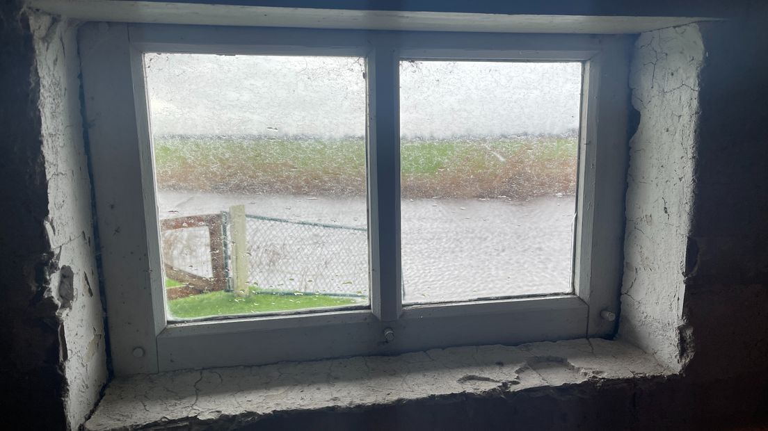 Hoog water in het Grootegaster Hoofddiep gezien door een raampje van de molen