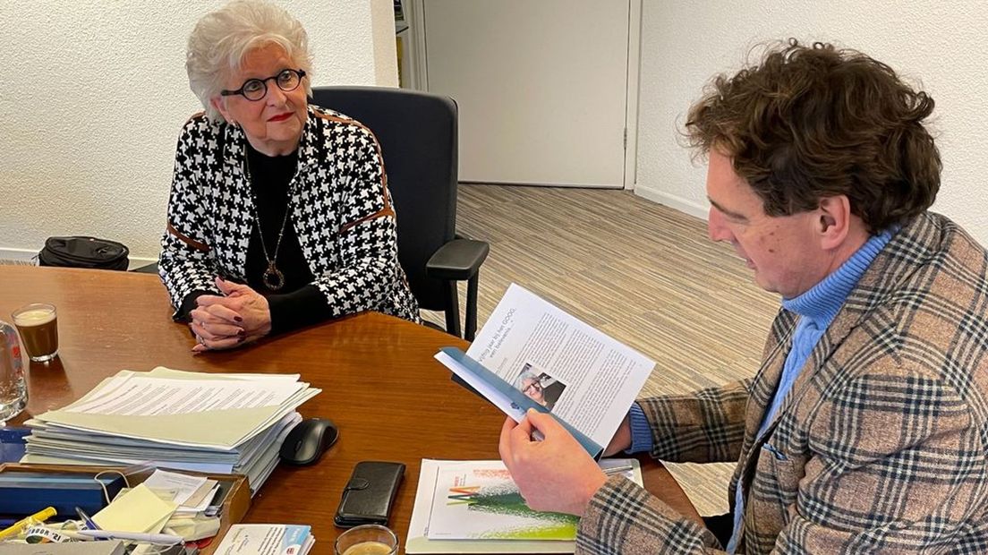 De burgemeester van Ede bladert door het boek van Ouwendijk.